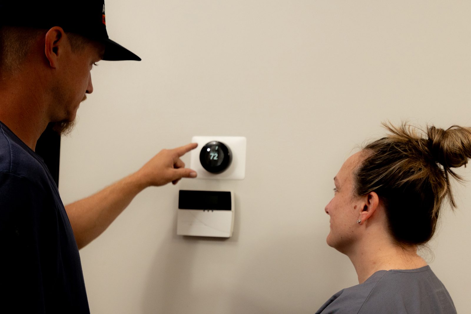All Set technician walking a homeowner through thermostat settings after a heating installation